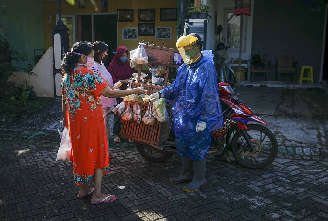 Mlijo atau Tukang Sayur Keliling di Kota Malang ini memakai Jas Hujan Plastik Kresek ala APD lengkap dengan masker+ faceshield dan sarung tangan karet gunamemutus penyebaran covid19 kepada para pelanggannya
