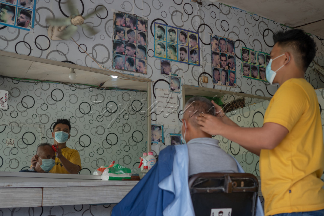 Untuk merdeka dari pandemi, maka harus taat prokes pencegahan covid khususnya dengan disiplin memakai masker dengan baik dan benar. <br />
<br />
Untuk merdeka dari tekanan ekonomi, maka harus mau semangat berusaha dan bekerja dengan segenap kemampuan yang dimiliki, tidak boleh berdiam diri atau pasrah saja. <br />
<br />
Untuk merdeka dari pandemi dan tekanan ekonomi, maka kita semua harus taat prokes dalam melaksanakan aktivitas sehari-hari, utamanya dalam aktivitas yang sangat penting seperti mencari nafkah atau bekerja. Hal ini terlihat pada Tukang Cukur di dalam foto yang tetap memakai masker dan pelanggannya pun harus tetap memakai masker. <br />
<br />
Dengan taat prokes dalam bekerja maka insya allah selamat dari virus covid sehingga pandemi bisa segera diatasi dan ekonomi tetap berjalan untuk kemajuan dan kesejahteraan rakyat Indonesia. 