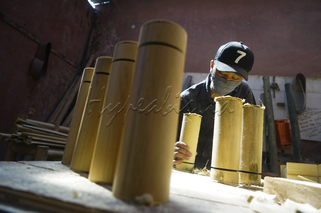 Pekerja menyelesaikan pembuatan tumbler atau wadah minuman dengan kemasan luar berbahan bambu di studio produksi Indonesian Bamboo Community (IBC), Jalan Melong Asih, Kota Cimahi. Semula IBC memproduksi alat musik berbahan bambu, namun saat pandemi produksi dialihkan pada pembuatan tumbler seiring menurunnya permintaan alat musik bambu. <br />
<br />
Mengandalkan bahan baku jenis Bambu Tali atau Bambu Apus, dalam bahasa Latin disebut Gigantochloa apus, produksi tumbler bambu dengan volume 500 ml ini dijual dengan harga antara Rp 100 ribu hingga Rp 250 ribu. Dalam satu bulan, rata-rata produksi mampu menghasilkan sebanyak 250 buah dengan sebaran konsumen di Bandung, Jakarta, Surabaya, Kalimantan hingga Bali.<br />
<br />
Prinsip eco-friendly diterapkan oleh IBC dalam memproduksi wadah minuman yang diberi merek Virageawie ini. Budaya masyarakat untuk menjalani hidup nol sampah, menjadi alasan terciptanya inovasi stainless tumbler yang dibalut dengan kemasan bambu. Selain untuk tampil beda menggunakan wadah minuman dengan ciri khas bambu Indonesia, konsumen dapat mengurangi penggunaan kemasan plastik sekali pakai.<br />

