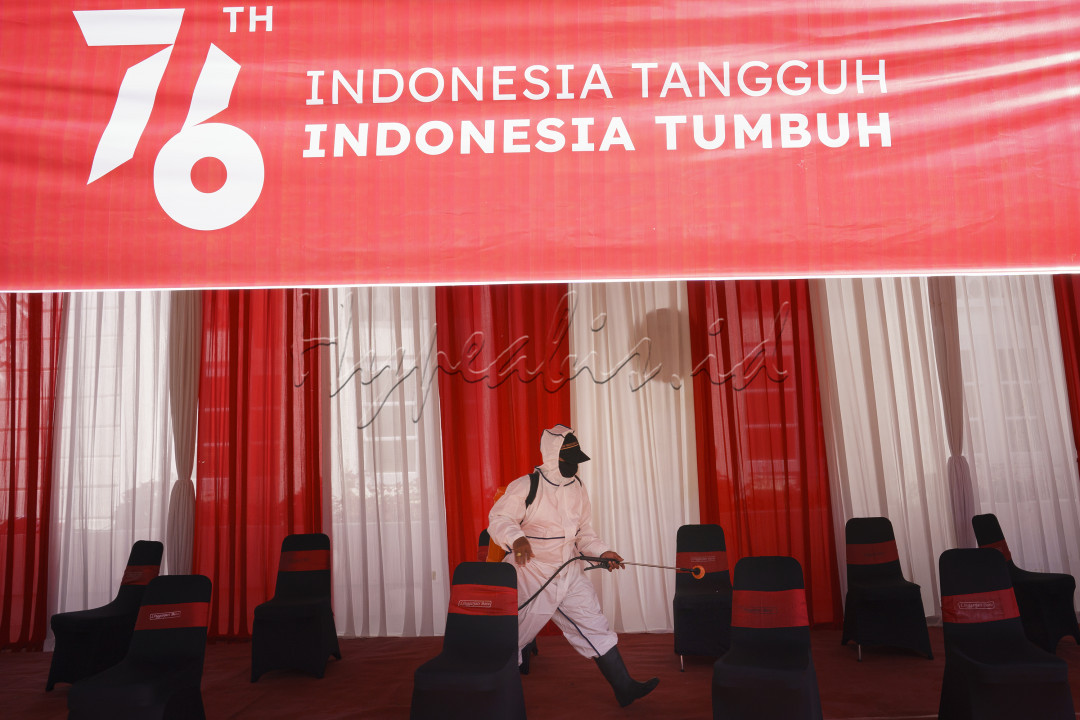 Tampak seorang petugas sedang melakukan pekerjaan desinfektasi ruangan terbuka untuk mencegah penularan virus covid 19 sebelum pelaksanaan upacara bendera kemerdekaan RI ke 76 dilaksanakan.