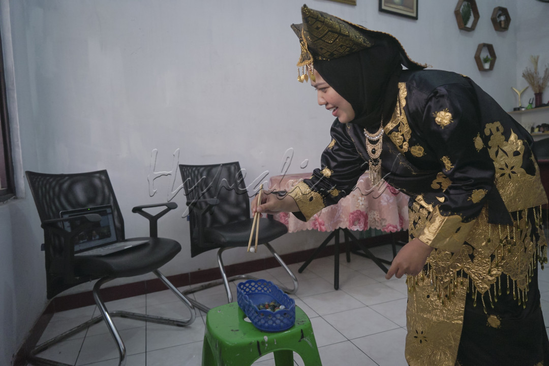Olivia Chyntia Dewi, karyawan sebuah perusahaan swasta mengenakan baju adat tradisional Minangåçkabau mengikuti lomba memindahkan kelereng secara daring di rumah masing-masing karyawan yang diselenggarakan oleh salah satu divisi perusahaan di kantornya, Tangerang, Provinsi Banten, 16 Agustus 2021. Kegiatan tersebut diisi dengan berbagai kompetisi seperti; Lomba lomba bekel, lomba makan kerupuk, lomba gerak kelereng, dan lomba busana daerah dalam rangka memeriahkan HUT RI ke-76 di tengah pandemi COVID-19. (Foto : Kurniawan Mas'ud)