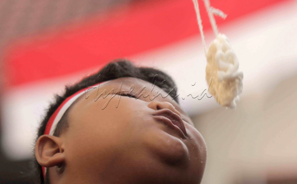 Ekspresi seorang anak saat mengikuti lomba makan krupuk dalam perayaan HUT RI ke 76 di Perum Lebo Permai Warung Asem Kab batang, 18 Agustus 2021