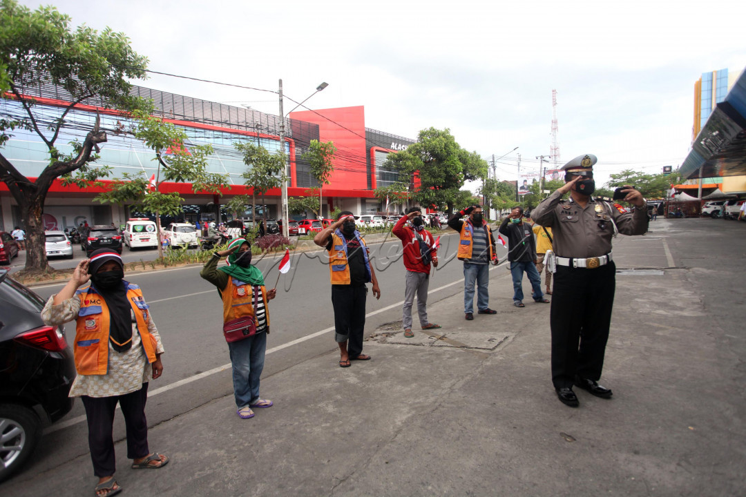 SEORANG Polisi Mengajak Jukir melakukan Upacara secara Virtual saat pengibaran Sang Saka Merah Putih di Istana .kegiatan ini berlangsung di jalan Pengayoman Makassar