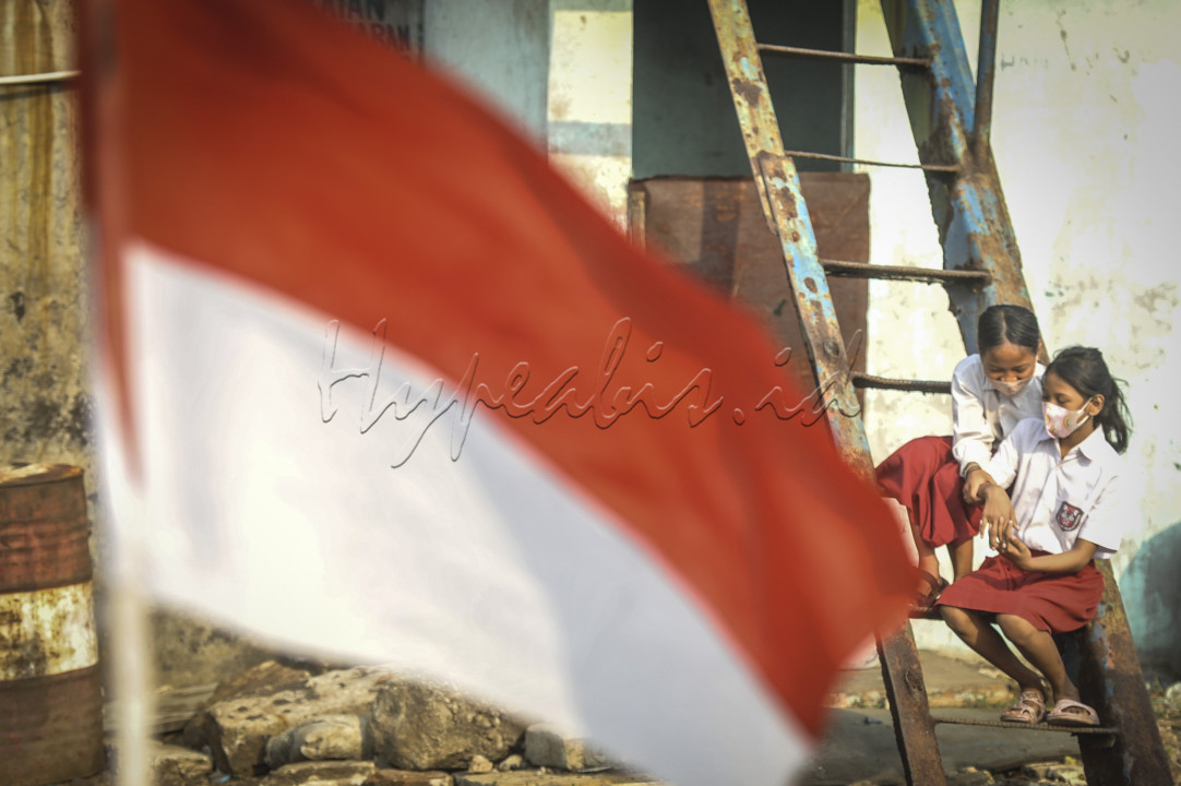 Anak-anak dari Komunitas Kelas Jurnalis Cilik mengikuti upacara bendera di kawasan Belah Kapal, Cilincing, Jakarta, Selasa (17/8/2021). Upacara yang diikuti sekitar 25 anak itu dalam rangka memperingati dan merayakan HUT Kemerdekaan ke-76 Republik Indonesia