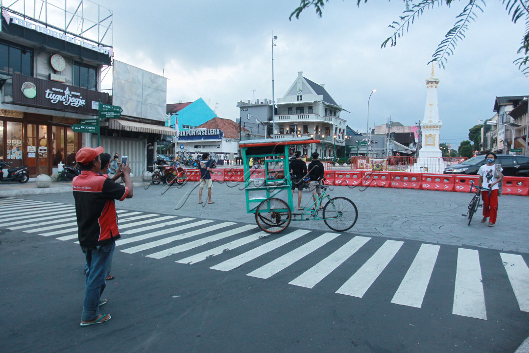 Pedagang memotret gerobak makanannya di kawasan Tugu Jogja yang ditutup aksesnya ke arah selatan atau Jalan Margo Utomo, Jogjakarta, Rabu (4/8/2021). Pedagang tersebut menyempatkan mengambil gambar gerobaknya yang kosong setelah makanan yang dia jual laris manis. 