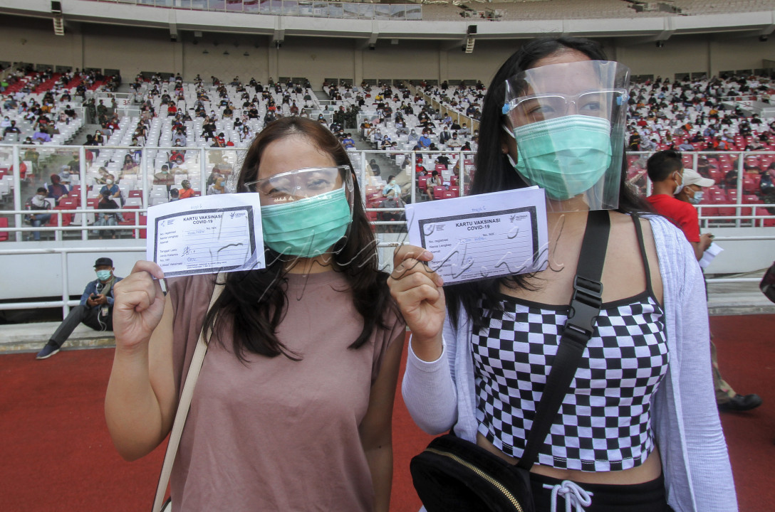 JAKARTA, INDONESIA, 3 Juli : Peserta memperlihatkan sertivikat usai menerima suntikan vaksin COVID-19 di stadion Gelora Bung Karno, Jakarta, Indonesia pada Sabtu 3 Juli 2021. Vaksin yang diperuntukkan umur 12 tahun keatas tersebut di ikuti sebanyak 11.500 warga yang ber KTP DKI Jakarta. Minat masyarakat ini melebihi target pemrov DKI yang menargetkan hanya 8ribu hingga 10 ribu peserta setiap hari. 