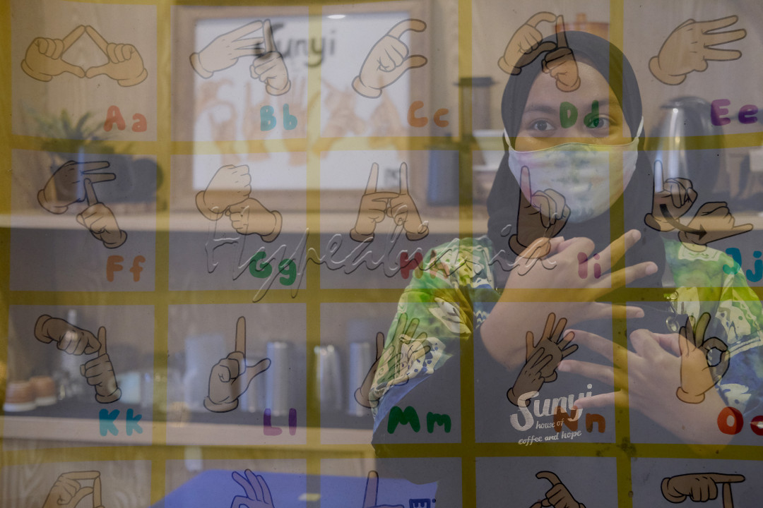 Gambar dengan teknis pencahayaan multiple exposure Barista Meir (25), melayani pengunjung dengan bahasa isyarat di kafe Sunyi “House of Coffee and Hope” di Jalan Fatmawati, Jakarta, Jum’at, 15 Januari 2021. Cafe sederhana ini menggambarkan kemerdekan mereka kaum difabel dalam kesetaraan memperoleh pekerjaan tanpa eksploitasi dalam dunia usaha. Foto: Ismail Pohan