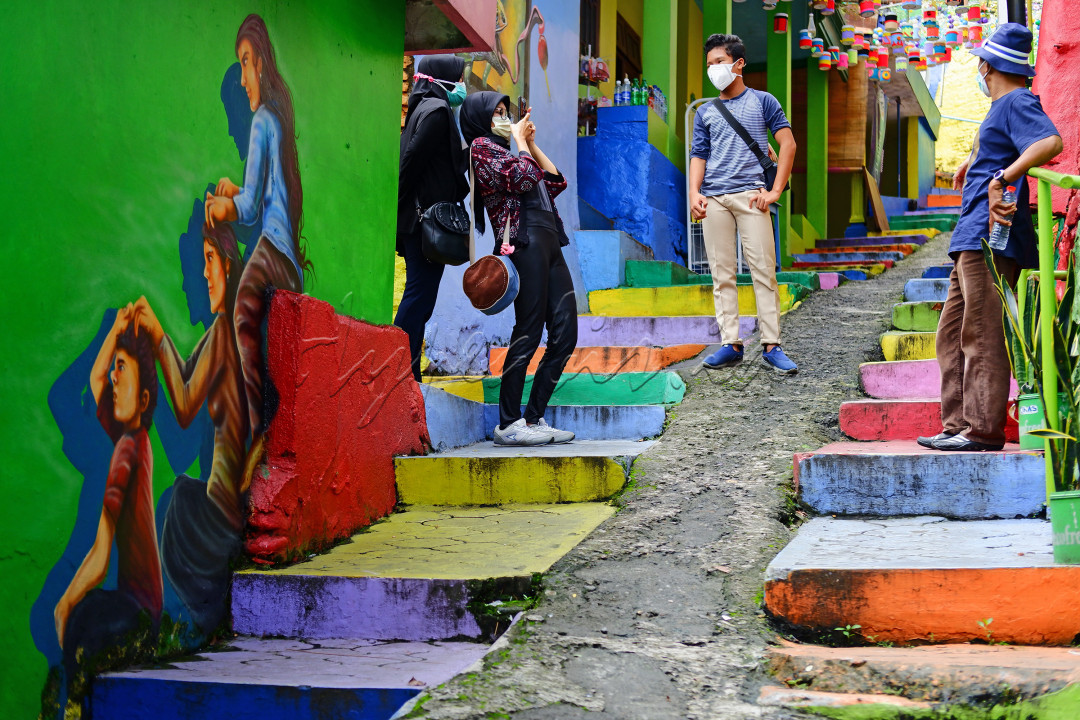 Sejumlah wisatawan dengan prokes menikmati pesona keindahan Kampung Warna Warni di Kota Malang. Kampung yang hits penuh warna dan mural ini sempat tutup selama pandemi, dan kemudian dibuka kembali dengan penerapan protokol kesehatan bagi pengunjung nya.<br />
<br />
Mural-mural kreatif karya anak kampung memenuhi gang-gang kampung wisata ini, menandakan mereka bebas berkreasi dan sebagai bentuk ekspresi kemerdekaan. Ketaatan pengunjung dalam menerapkan prokes pun menjadikan mereka tetap bebas merdeka untuk menikmati pesona Indonesia.