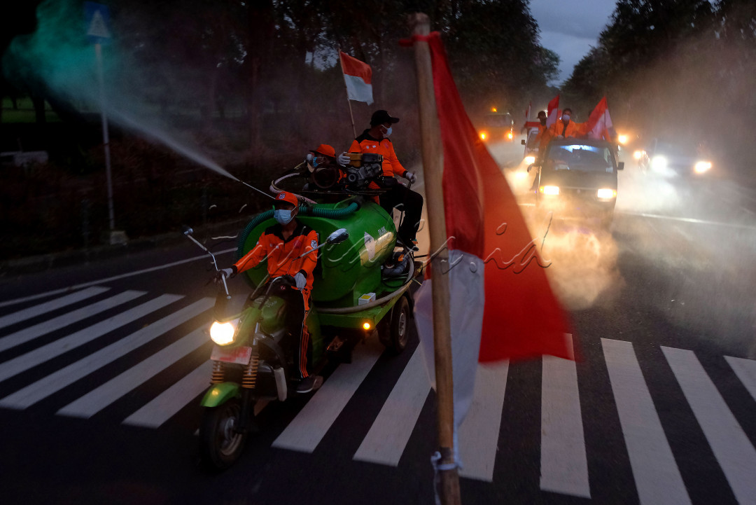 Tim Reaksi Cepat dan Satgas COVID-19 Tangguh Dewata menyemprotkan cairan disinfektan dengan membawa bendera merah putih dengan diiringi alunan lagu perjuangan dalam perjalanan berkeliling Desa Sumerta Kelod, Denpasar, Bali, Selasa (17/8/2021). Kegiatan yang dimulai pada pukul 06.00 - 08.00 WITA tersebut untuk merayakan HUT Kemerdekaan ke-76 Republik Indonesia pada masa pandemi COVID-19 sekaligus upaya pencegahan penyebaran COVID-19 yang jumlah kasusnya masih tinggi di kawasan itu. 