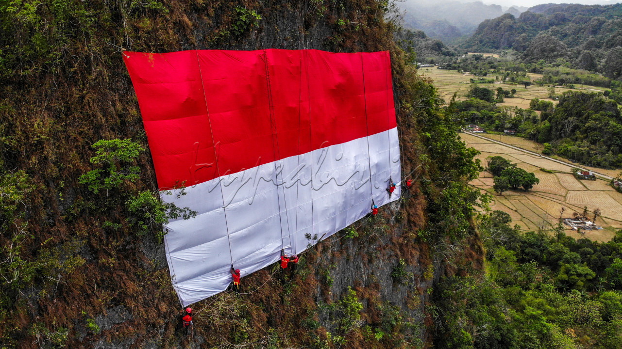 Prosesi pengibaran bendera merah putih di tebing karts Leang Leang,<br />
Kabupaten Maros, Selasa (17/08/2021). Bendera sepanjang 25m x 15m di<br />
bentangkan pada tebing setinggi 150m oleh anggota Mapala 45 Makassar<br />
dalam rangka memperingati HUT Republik Indonesia.