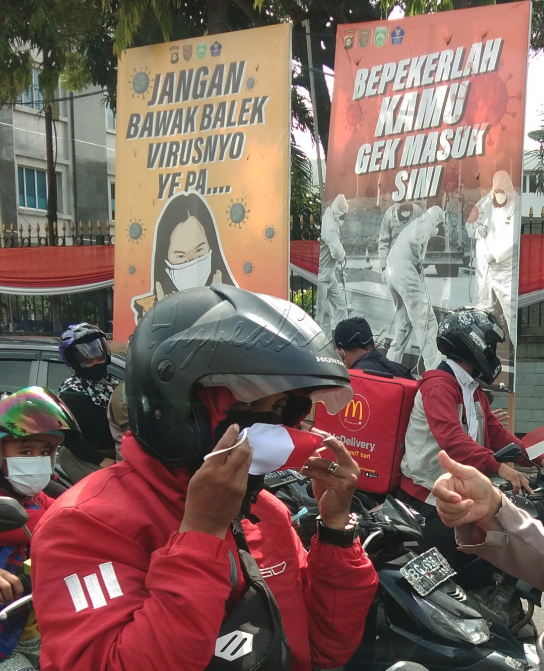 Pakai Masker. Pengendara motor memperbaiki masker Yang ia gunakan sebanyak dua lapis di Traficlight Simpang Charitas Palembang, dimana dikawasan tersebut terdapat baliho agar kita menggunakan masker Sehingga kita, keluarga dan masyarakat terhindar dari Covid 19.Maka kita dapat merdeka dari pandemi covid 19. 