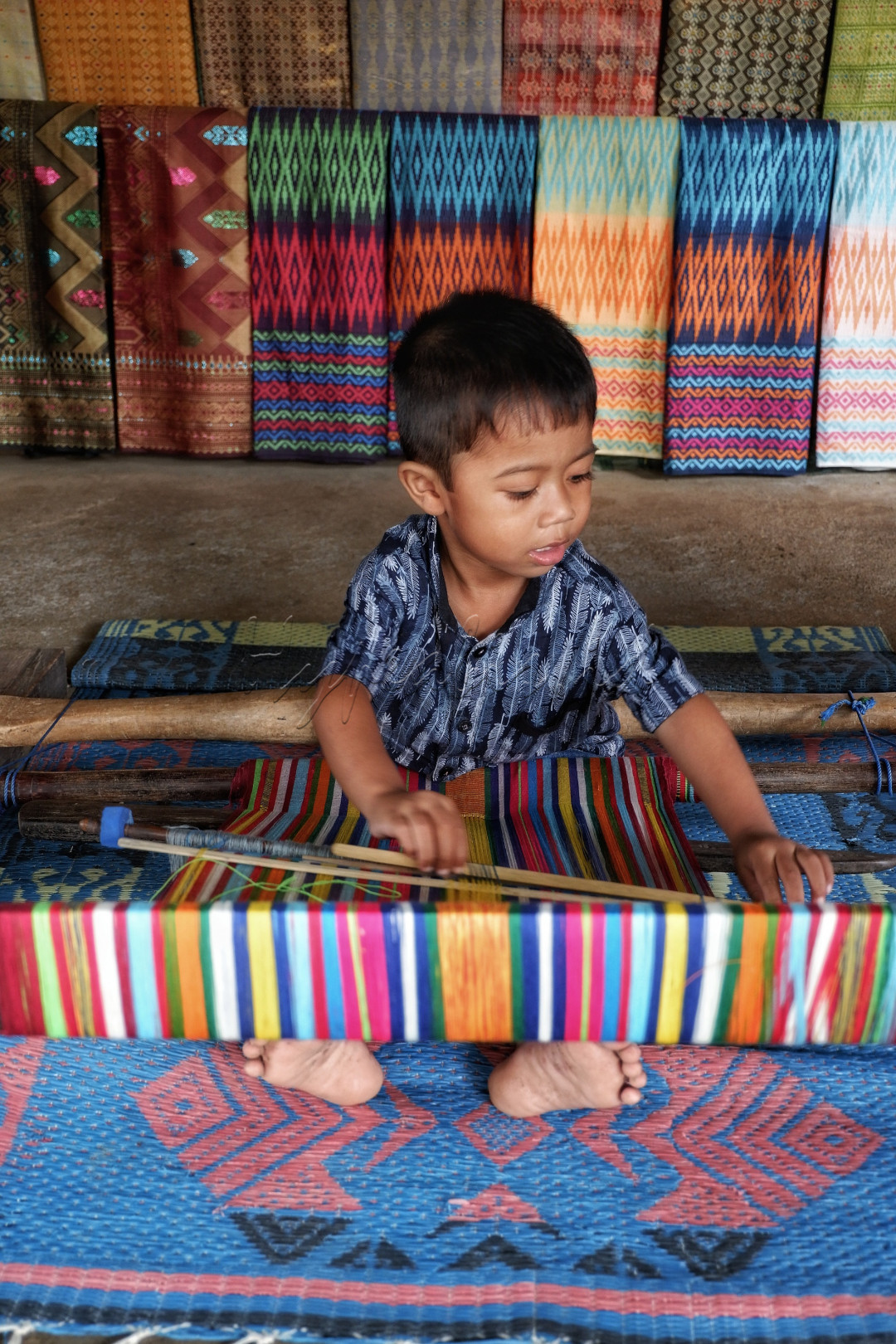 Terlihat seorang Bocah laki-laki yang sedang belajar menenun.. <br />
dengan semangatnya dia mencoba menjelaskan cara caranya kepada kami.. <br />
Ini adalah kain tenun Songket khas Lombok