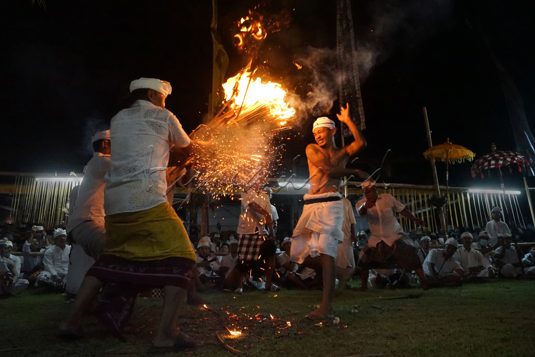 Sebuah tradisi yang berlangsung di Klungkung, Bali. Pada upacara ini, para pengayah yang dalam kondisi setengah<em> trance </em>meminta sarana geni / api, untuk sebuah persembahan.