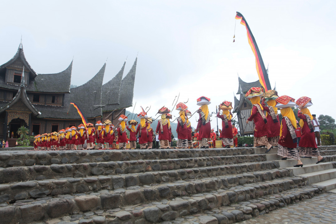 Perempuan Minangkabau atau bundo kanduang mengarak jamba 'Arak Jamba' yang berisi makanan di kawasan Istano Basa Pagaruyuang, Batusangkar, Sumbar, Minggu (19/01/2020). Tradisi Arak Jamba digelar ketika menyambut tamu yang datang atau pada pesta pernikahan. 