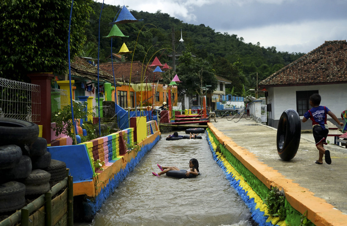 <br />
Anak-anak mengarungi aliran irigasi menggunakan ban dalam bekas di Kampung Kreatif Babakan Caringin, Desa Cipanas Kecamatan Tanjung Kerta, Kabupaten Sumedang. Keberadaan aliran irigasi mata air Cikandung dimanfaatkan karang taruna setempat sebagai wahana bermain anak dengan menyewakan ban sebagai pelampung renang seharga Rp 2 ribu per jam. Selain berpotensi menambah pendapatan bagi karang taruna, wahana tubing di Kampung Kreatif Babakan Caringin ini menjadi upaya untuk mengangkat potensi wisata desa. 