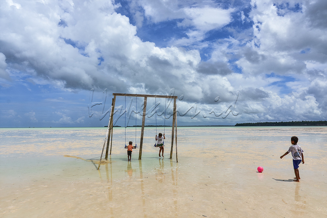 Sejumlah bocah Kei bermain ayunan di tengah pantai yang surut jauh atau Meti di Desa Wisata Ohoidertawun, Kabupaten Maluku Tenggara (Malra), Provinsi Maluku, pada 29 Oktober 2021. Masyarakat Malra di Kepulauan Kei memanfaatkan fenomena alam Meti menjadi daya tarik wisata, dan pemerintah daerah mengemasnya dalam bentuk festival Meti Kei yang kini menjadi agenda Kementerian Pariwisata dan Ekonomi Kreatif untuk kategori "Kharisma Event Nusantara skala regional".