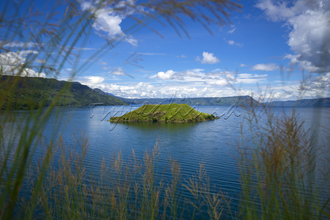 Pemandangan danau Toba dengan Pulau Hole di tengah danau yang dilihat dari Bukit Sipolha, Pematang Sidamanik, Kabupaten Simalungun, Sumatera Utara, MInggu (12/07/2020).<br />
Pulau Hole, merupakan pulau kecil di tengah danau Toba yang tidak berpenghuni akan tetapi dapat dijadikan area camping.