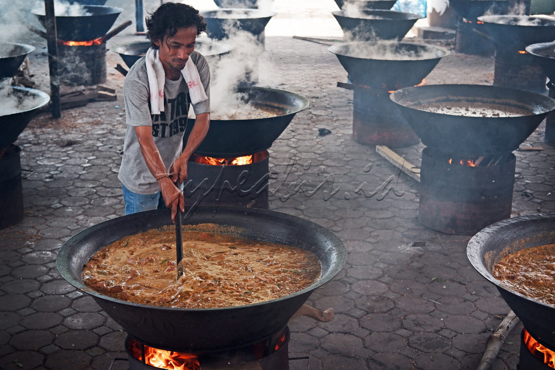 Warga Desa Ateuk Munjeng, Kota Banda Aceh memasak Kuah Beulangong, kuliner khas Aceh yang terbuat dari gulai daging yang dimasak di wajan berukuran besar. Masakan ini nantinya akan dibagikan kepada seluruh warga desa. Acara ini dalam rangka tradisi Kenduri Kuah Beulangong yang kerap diadakan saat memasuki hari 17 bulan ramadhan. Foto diambil pada 01 Mei 2021