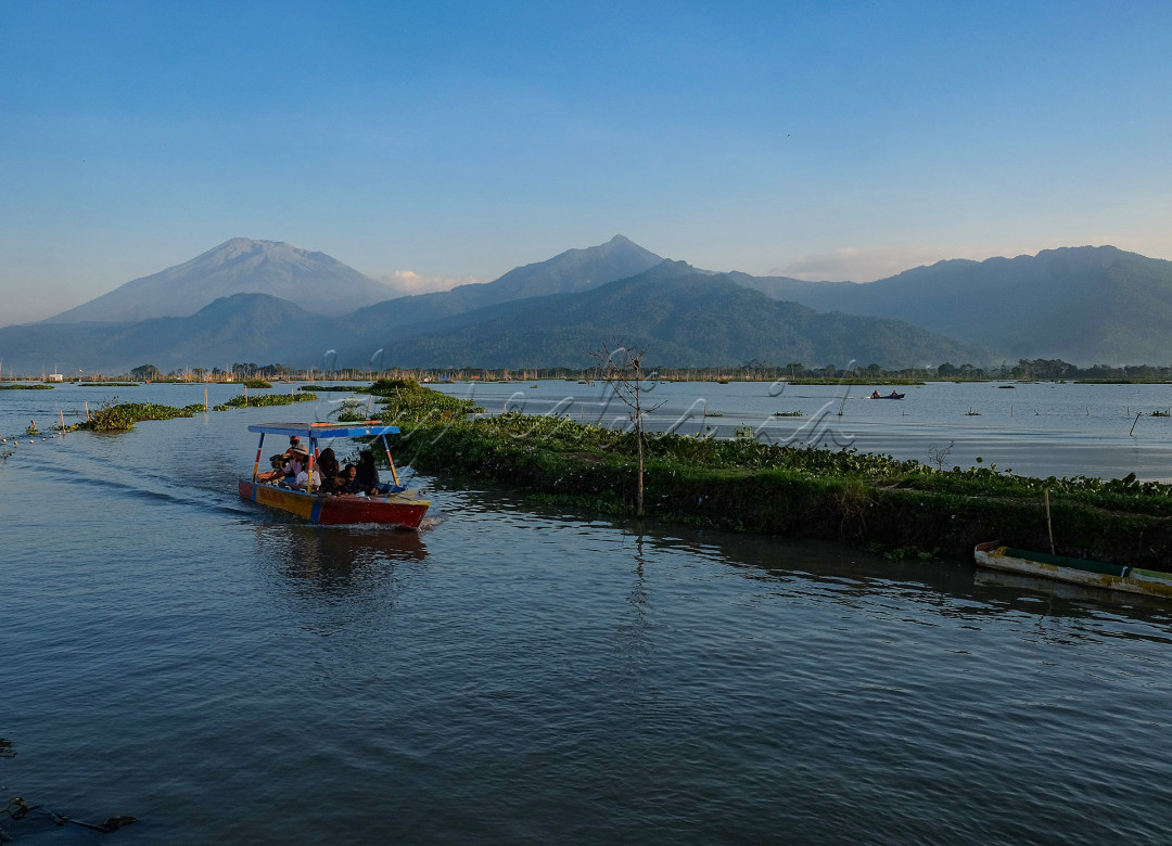 Rawa Pening merupakan salah satu objek wisata alam danau dengan luas 2.670 hektare yang terletak di Kecamatan Ambarawa, Bawen, Tuntang dwn Banyubiru, Kabupaten Semarang, Jawa Tengah. Rawa Pening terletak di cekungam terendag lereng Gunung Merbabu, Gunung Telomoyo dan Gunung Ungaran. Kita tidak hanya bisa singgah di sekitar danau dan menikmati keindahan danau, namun kita juga bisa menyewa perahu untuk berkeliling danau rawa pening. Tarif untuk menyewa perahu adalah Rp. 100.000 selama 15menit. Saat berkeliling danau, kita bisa melihat banyak tanaman enceng gondok yang tersebar di permukaan danau Rawa Pening. Selain itu, pemandangan di sepanjang danau juga sangat indah dengan latar belakang gung Telomoyo, gunung Ungaran dan gunung Merbabu. Di sepanjang danau juga terdapat pondok terapung milik nelayan yang mencari ikan di danau Rawa Pening. Untuk keselamatan, penumpang disediakan pelampung yang dikenakan penumpang saat menyusuri danau Rawa Pening menggunakan perahu.<br />
<br />
<br />
