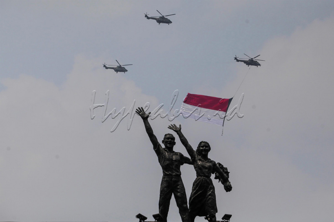 Tiga helikopter TNI AU terbang melintas sambil mengibarkan bendera merah putih saat Upacara Peringatan Detik-Detik Proklamasi di kawasan Bunderan HI, Jakarta, Selasa (17/8/2021). Sebanyak enam helikopter TNI AU mengibarkan bendera merah putih berukuran 20 x 30 meter dalam rangka memperingati HUT kemerdekaan ke-76 RI. 