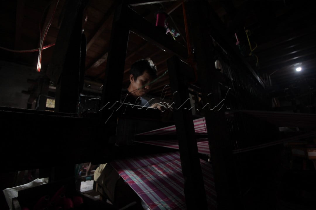 Judul : Alat Tradisional<br />
Pengrajin menenun kain tajung khas Palembang produksi rumahan dengan menggunakan alat tradisonal di kediamannya, kawasan Tuan Kentang, 15 Ulu, Kota Palembang, rabu, 20 artiOktober 2021. 