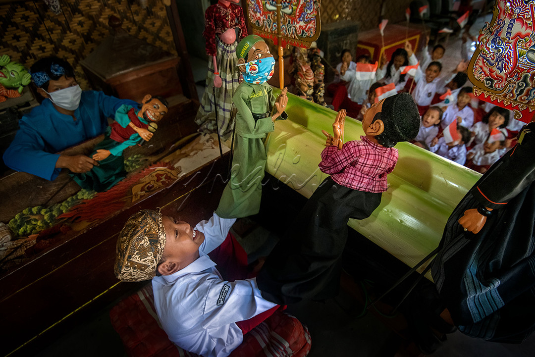 Seorang dalang cilik dari siswa sekolah Dasar di Indramayu, sedang memainkan wayang dengan lakon Covid-19