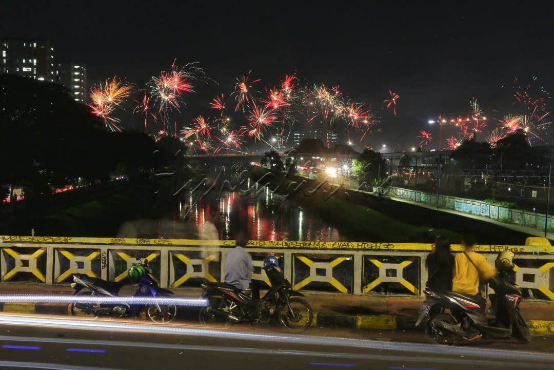 Warga menyaksikan kembang api saat malam pergantian Tahun Baru 2022 di Kawasan Tanah Abang, Jakarta, Jumat (31/12/2021). 