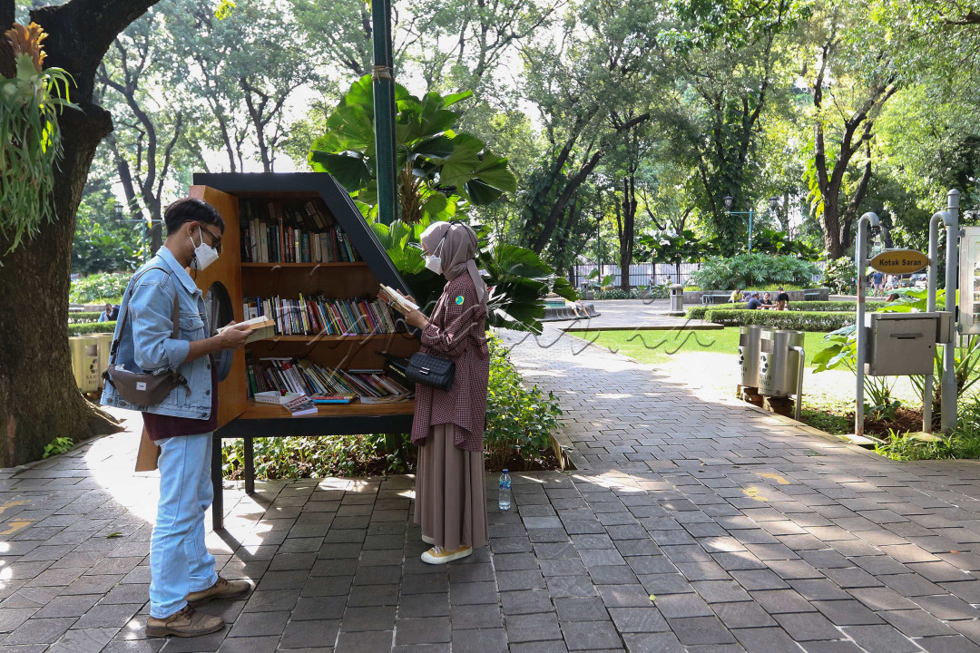  Pengunjung membaca buku di perpustakaan mini Taman Suropati, Jakarta. Membaca buku di ruang terbuka disebut memiliki banyak manfaat, membaca di bawah cahaya terang membuat area otak bisa memproses informasi visual secara lebih efektif. <br />
<br />
