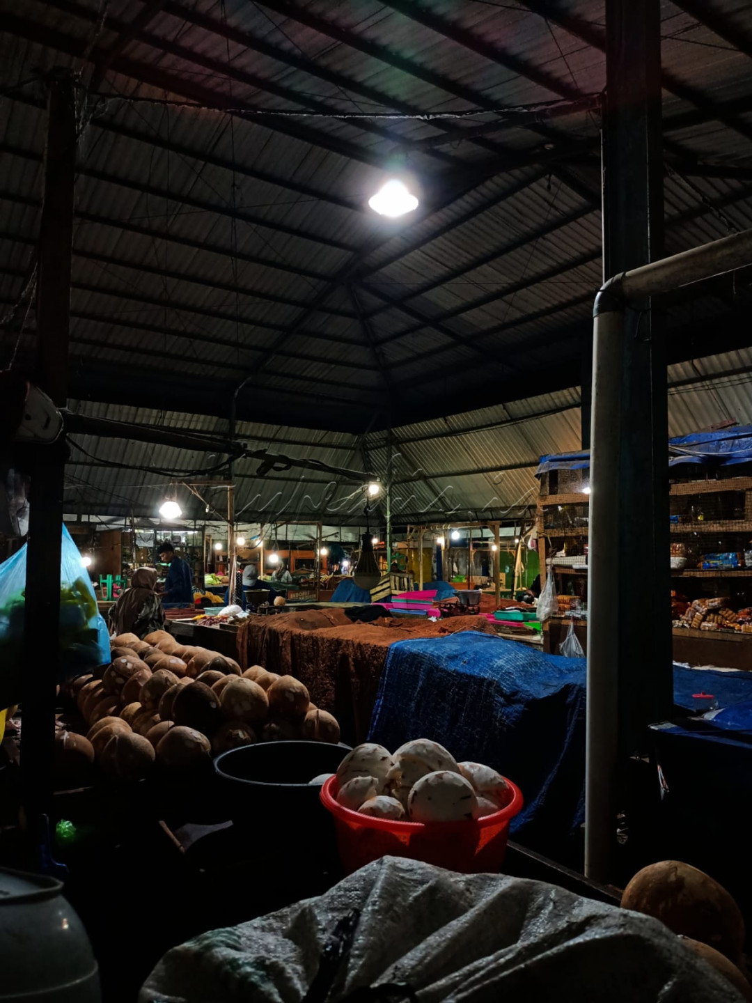 Suasana pasar yang masih gelap tetapi barang dagangan mulai berjejer dan sudah mulai terlihat beberapa penjual yang datang mulai sibuk beraktivitas.