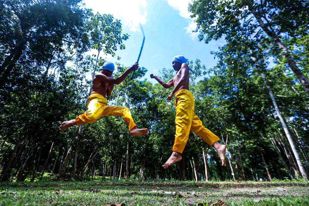 Dentuman alat musik tradisional seperti gong, tawak, kelinang dan serunai mengiringi dua orang pemuda memasuki gelanggang pertarungan.<br />
<br />
<br />
<br />
