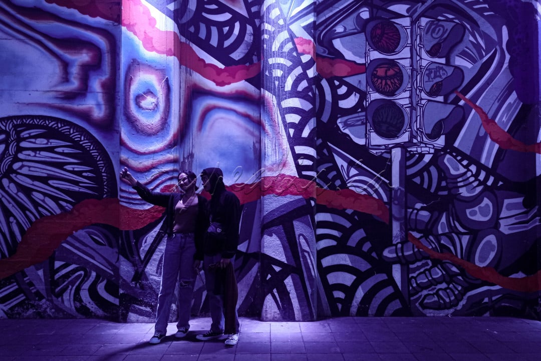 Pengunjung saat berswafoto di Terowongan Kendal Dukuh Atas. Jakarta, Sabtu (28/5/22). Terowongan tersebut kini lebih menarik dengan dihiasi mural dan lampu berwana-warni yang memberikan spot foto intagramable.