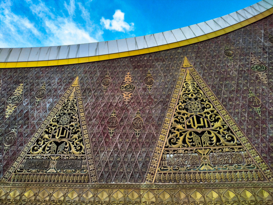 Bagian dinding masjid ini dipenuhi oleh ukiran khas minangkabau dan kaligrafi, dengan warna dominan merah dan kuning. Hal ini tentunya sekaligus memperkanalkan seni budaya minangkabau kepada seluruh pengunjung masjid.