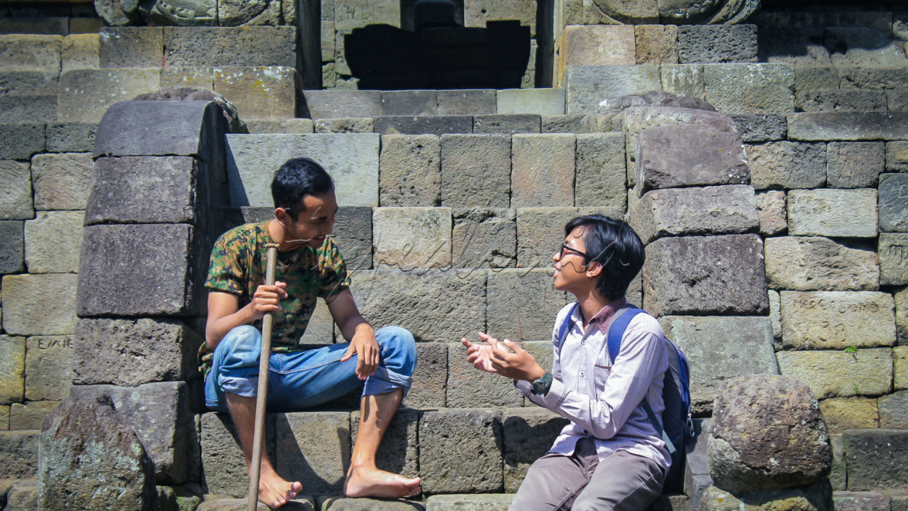 Pada foto ini mengambarkan <strong>symphony kegembiraan.</strong><br />
<br />
<strong>Mahasiswa</strong> (orang berkacamata dan beransel) berdiskusi dengan <strong>seorang penduduk asli</strong> berdiskusi tentang indahnya Indonesia, mereka berdua bertukar senyuman, untuk menciptakan suasana kehangatan.