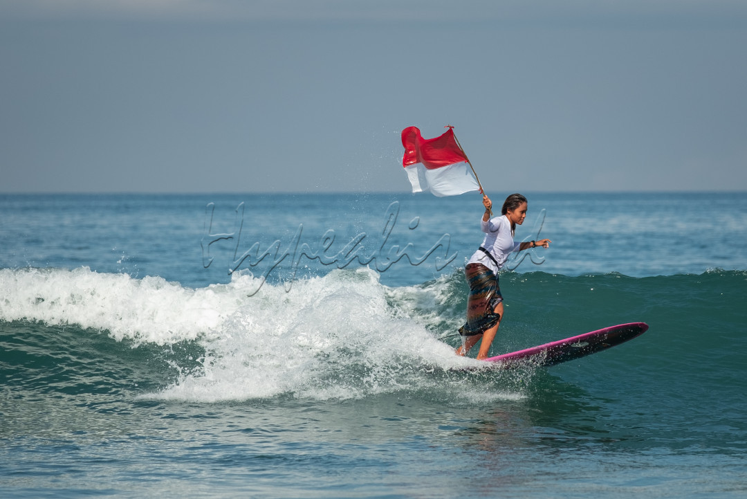 Rasa cinta terhadap tanah air bisa ditunjukkan dalam berbagai hal oleh masyarakat Indonesia, contohnya Peselancar perempuan mengenakan kebaya dan membawa bendera merah putih saat beraksi di pantai Kuta Bali. 