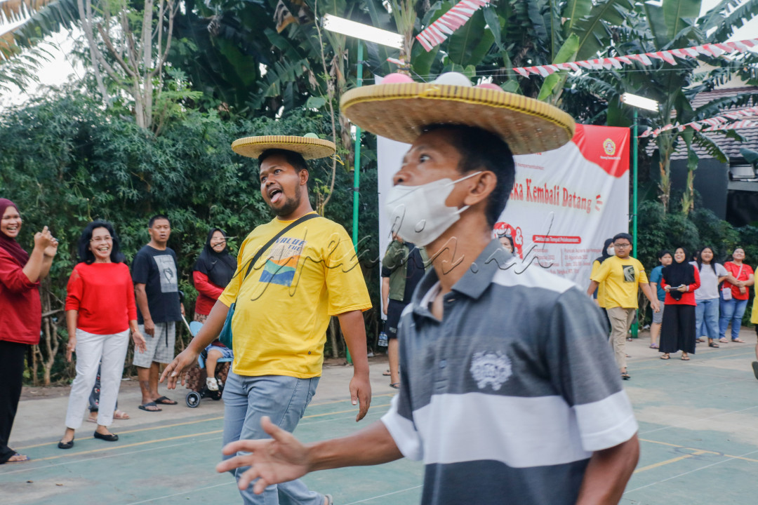 Lomba balap tampah ini dilakukan oleh bapak-bapak. Bukannya fokus agar cepat sampai garis <em>Finish,</em> sempat-sempatnya bapak yang memakai baju warna kuning itu berekspresi konyol hingga membuat penonton tertawa.