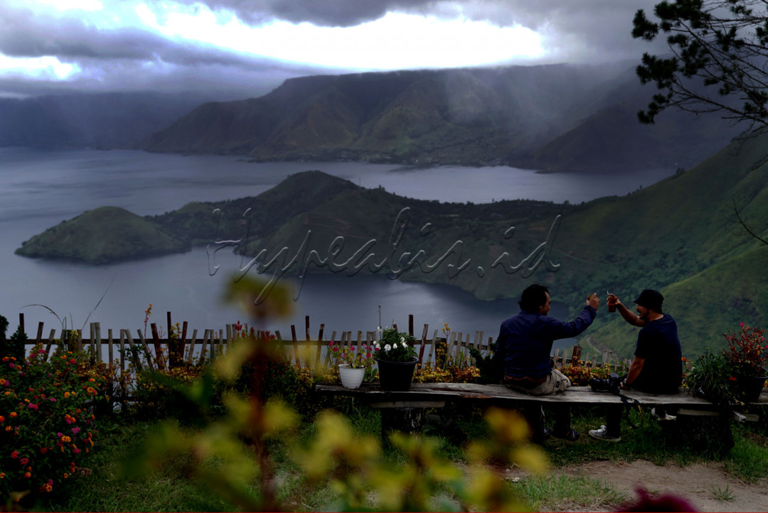 Dua Wisatawan menikmati panorama Danau Toba di Desa Sipan Kabupaten Simalungun, Sumatera Utara.