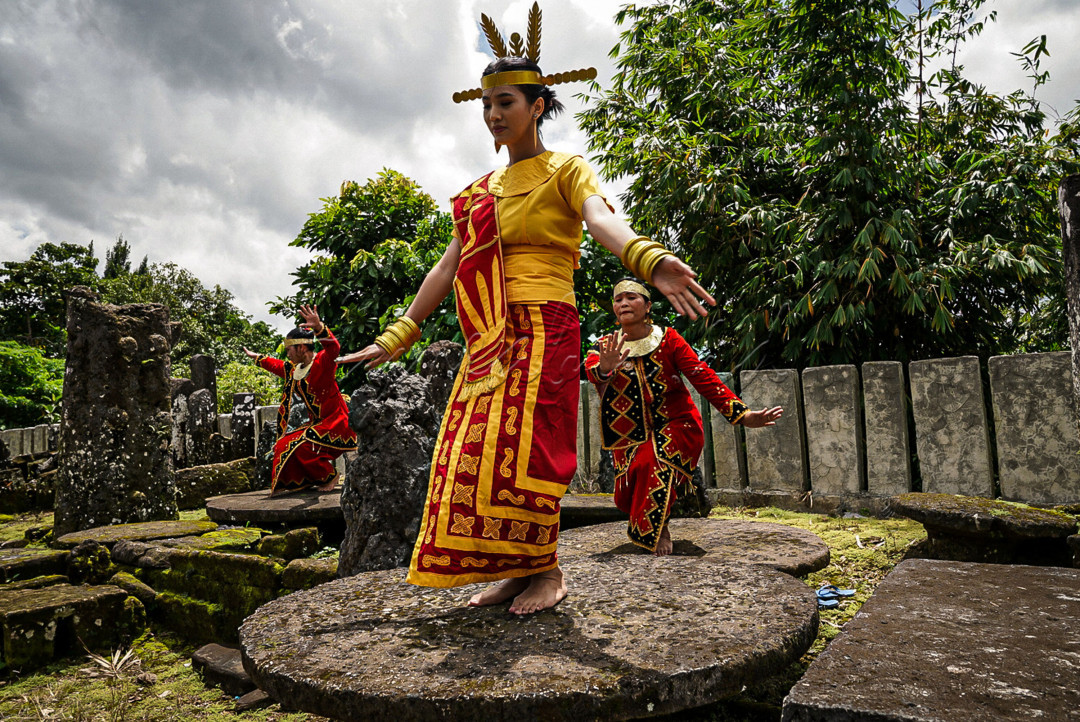 Tiga perempuan suku Nias menari Moyo di kawasan situs batu megalit Tundrumbaho, Kabupaten Nias Selatan, Sumatera Utara 