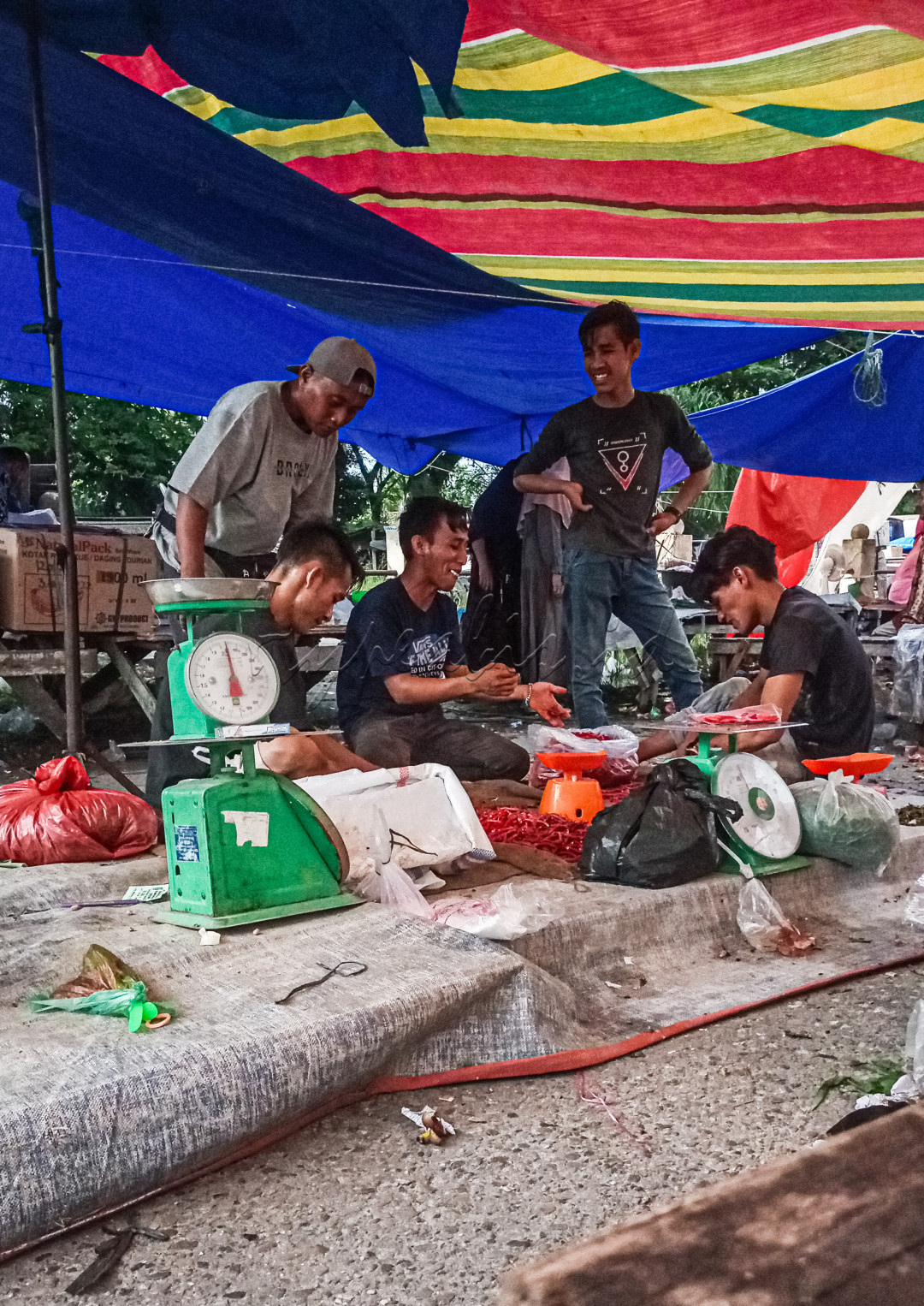 SEKELOMPOK Pedagang Pasar Tradisional sedang Bercengkerama antar sesama, setelah sejak pagi sampai sore melakukan aktivitas berjualan di pasar tradisional Danau Bingkuang, Kecamatan Tambang, Kampar, Riau