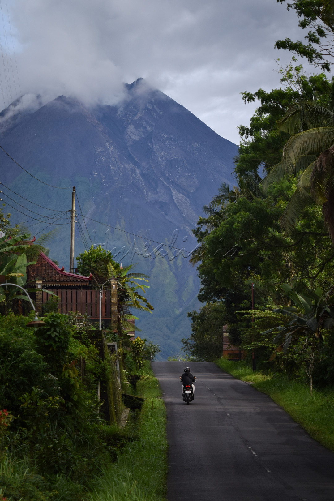 Seorang warga melintas di dusun Kepuharjo, salah satu dari kawasan wisata di kabupaten Sleman.