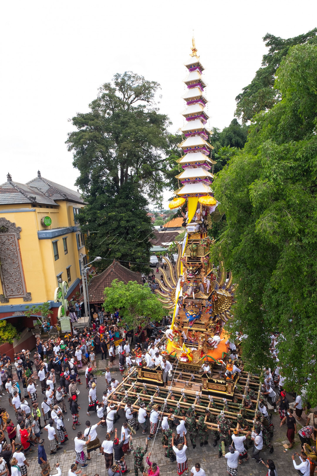 Masyarakat desa Ubud dibantu anggota TNI bahu-membahu mengusung tempat jenasah<br />
atau di Bali disebut Bade yang tingginya lebih dari 20 meter sebelum sampai di tempat pembakaran jenasah. Bali 26 Februari 2022<br />
