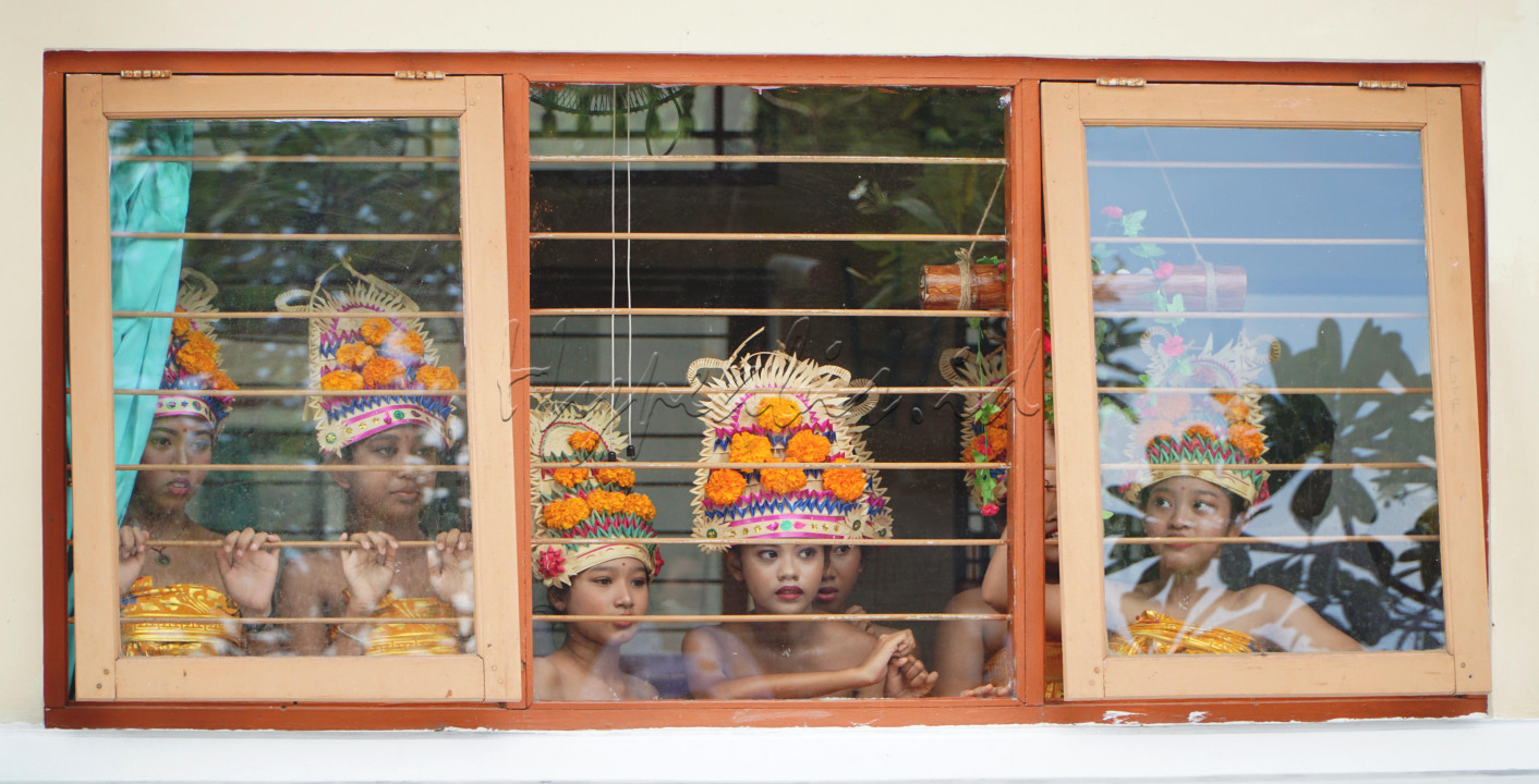 Foto ini diambil pada saat perayaan Hari Raya Saraswati di salah satu SMP Negeri di Kota Denpasar. Beberapa penari ini adalah siswi yang terpilih untuk menarikan tarian sakral Rejang Dewa. Tarian ini biasa ditampilkan pada saat ada upacara keagamaan. <br />
Para penari terlihat berada di balik jeruji besi, mengamati penari lainnya yang sedang menari dengan lincahnya. Mereka sangat terpesona melihat teman teman mereka menari dengan penuh pengahayatan sebagai wujud rasa syukur kepada Sang Maha Pencipta