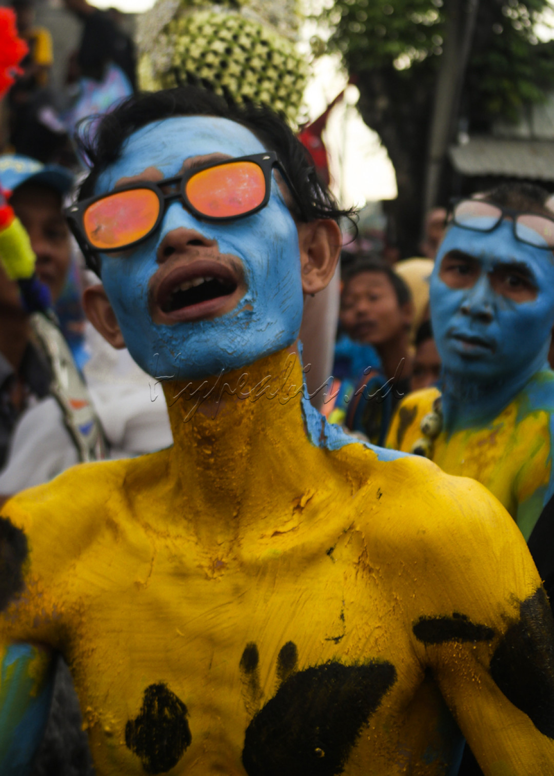 Peserta ider-ideran Memayu Trusmi melakukan pertunjukan seni. Ia mengecat tubuh dengan warna kuning dan biru. 