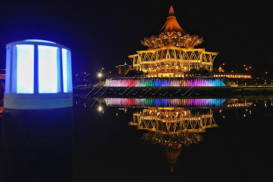 Kerlip-kerlip lampu warna-warni pada air mancur menghiasi gedung Dewan Undangan Negeri Sarawak di Kuching Waterfront, Kuching, Malaysia.