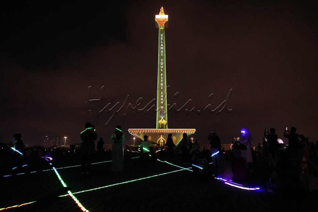 Pengunjung menyaksikan pertunjukan 'video mapping' di Monumen Nasional (Monas), Jakarta, Senin (24/4/2023).