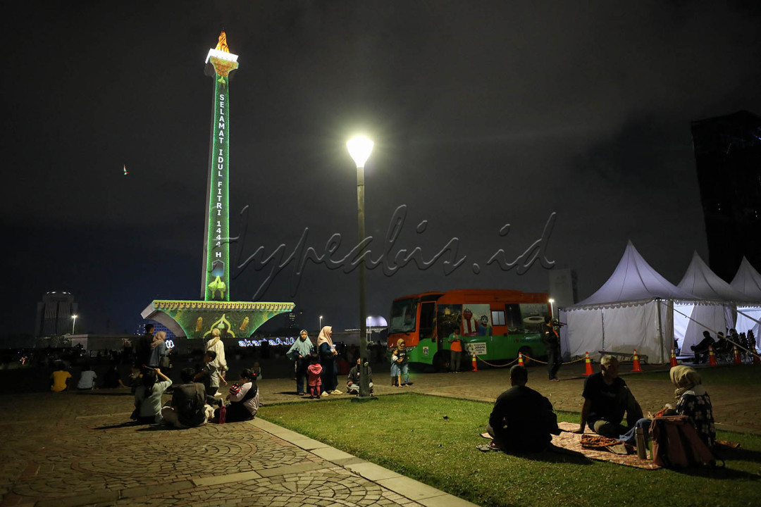 Video mapping Monas terlihat bernuansa Idul Fitri 1444 H dengan gambar warna-warni bertema lebaran.<br />
