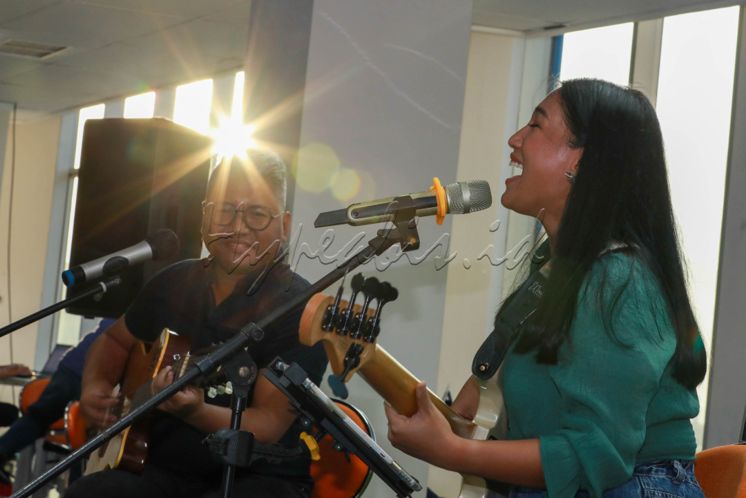 Pasangan gitaris Andre Dinuth dan basis Wanda Omar melakukan jamming akustik dalam acara Kamis Santuy di ruang redaksi Bisnis Indonesia.