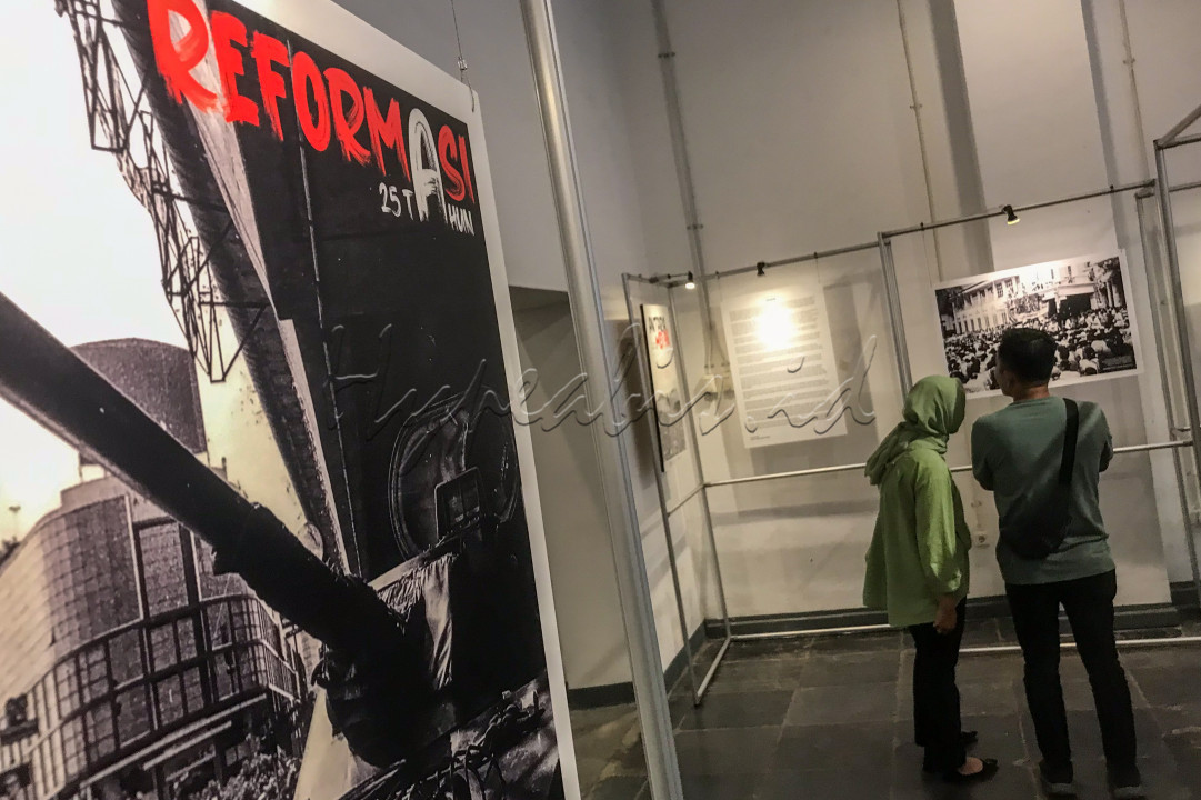 Pengunjung melihat karya foto peristiwa Reformasi 1998 di Pos Bloc, Jakarta.