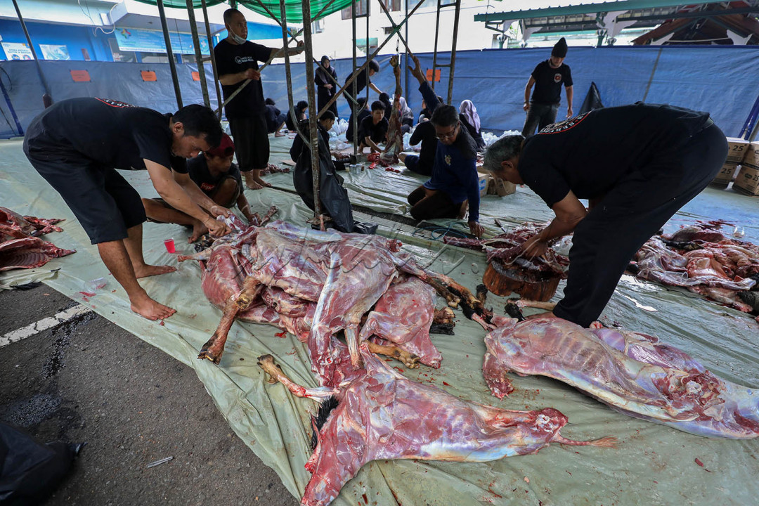 Petugas memotong daging kurban sebelum dibagikan ke warga