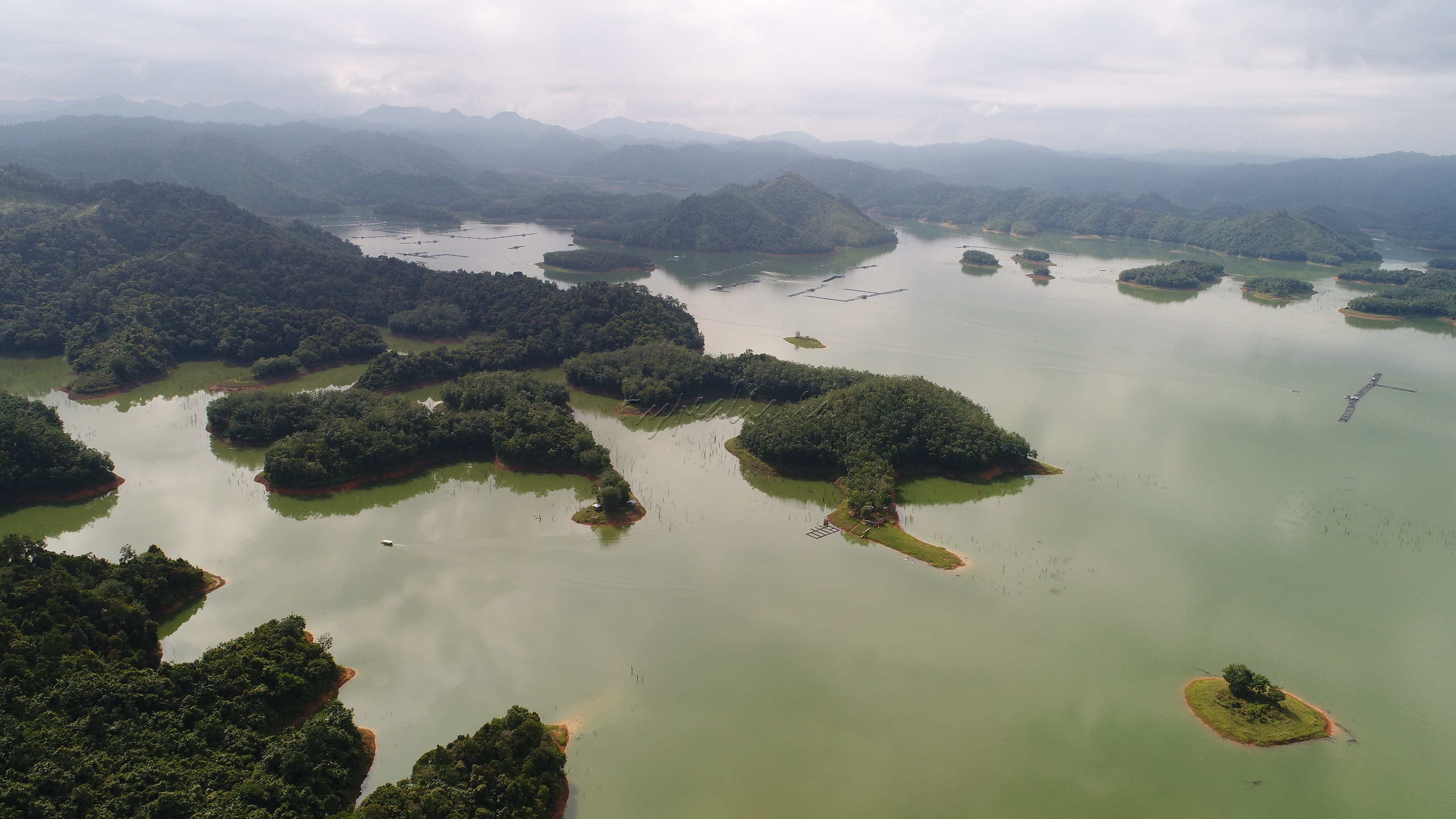 Dari atas bukit, pemandangan danau di bawahnya memang serupa Raja Ampat; gugusan pulau kecil dengan air danau berwarna tosca atau biru pirus.