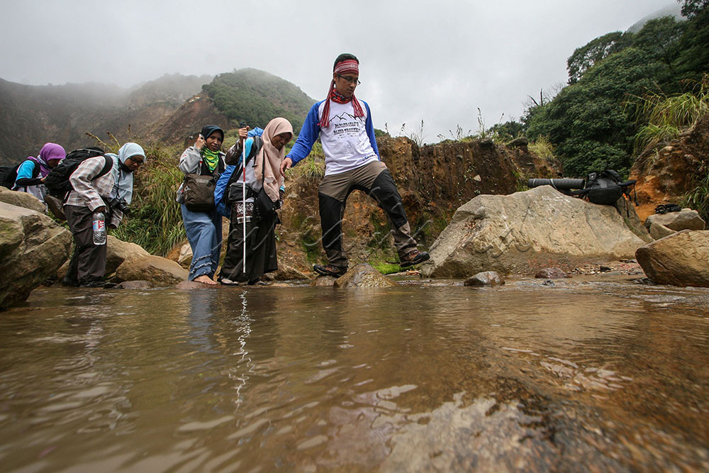 Pendaki menyebrangi sungai kecil untuk menuju Pondok Saladah, Gunung Papandayan di Garut, Jawa Barat.